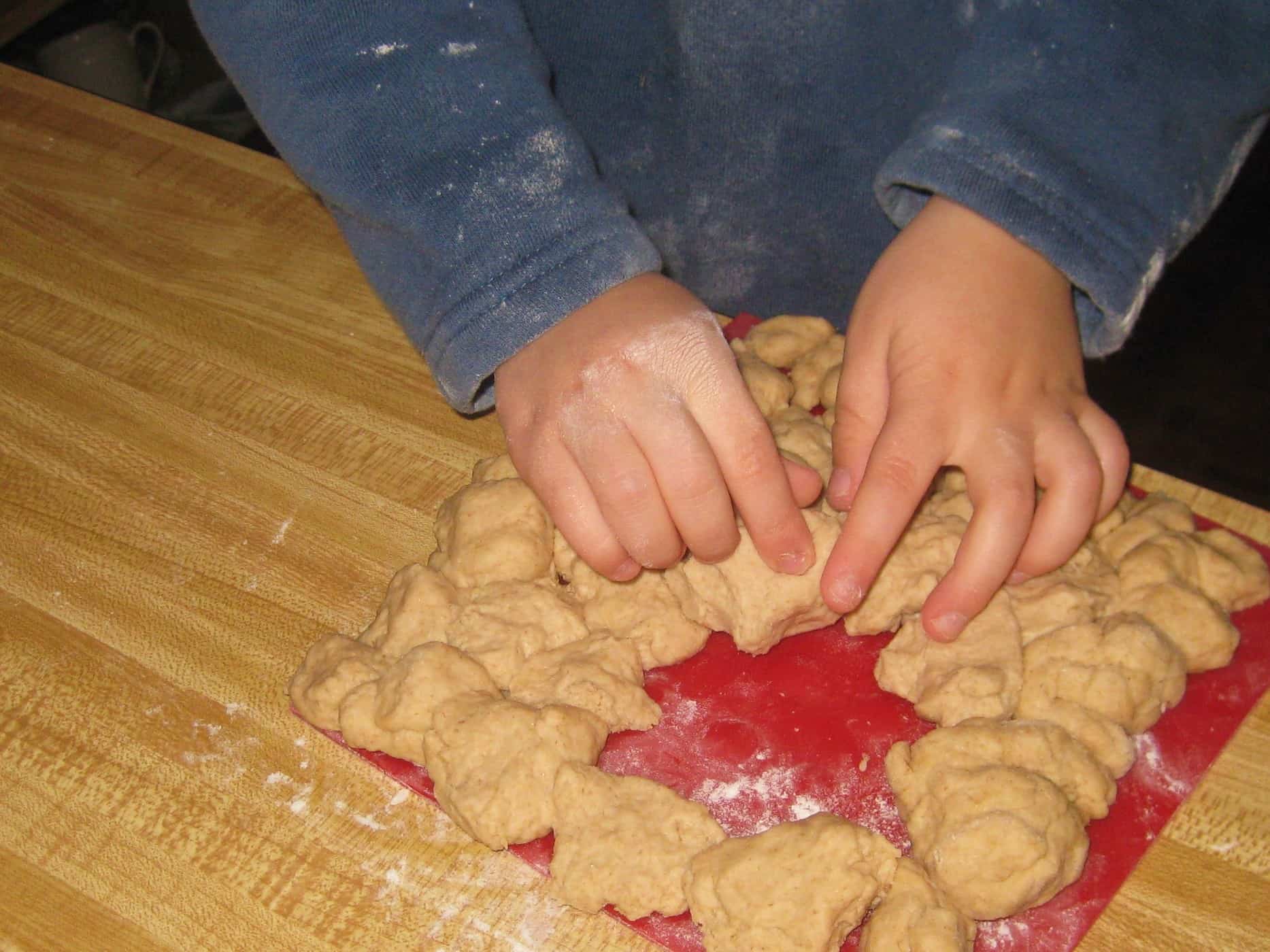little boy's hands playing with bread dough