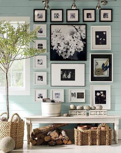 accent wall of many pictures, bench and tree in large basket