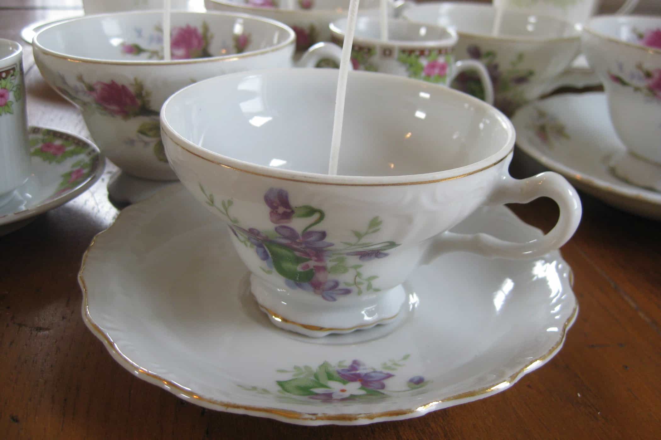 floral teacups on table with wicks
