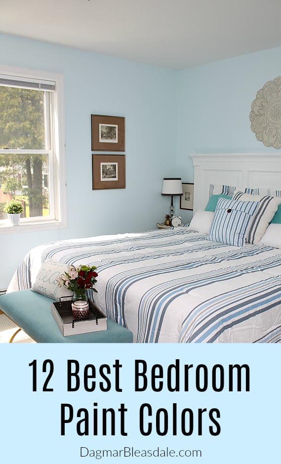 light blue bedroom with bed, striped blanket and pillows, bench in front of bed, window