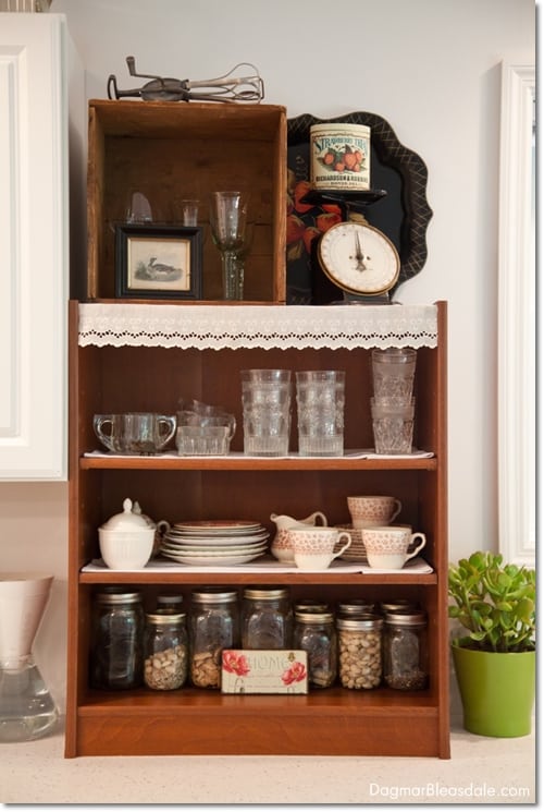 brown shelf and crate with glasses on dishes on kitchen counter