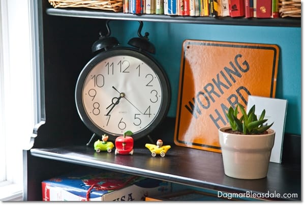 bookshelf with clock and books, plant and figurines