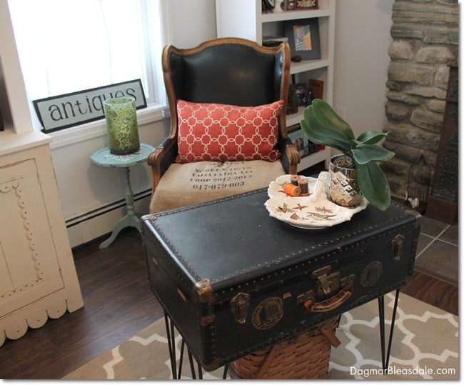 vintage trunk coffee table next to vintage chair in cottage living room