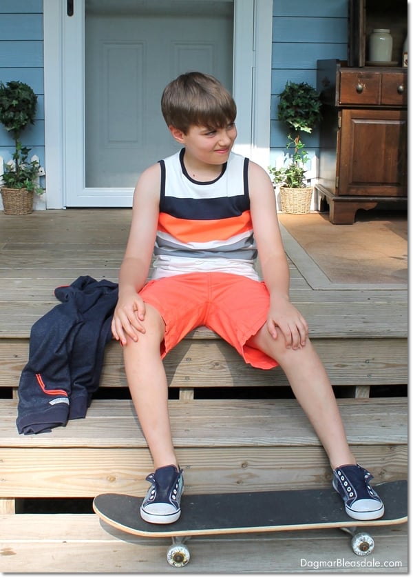 boy sitting on porch with skateboard