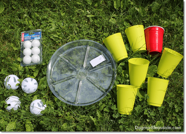 plastic balls, plastic saucer, plastic cups in the grass