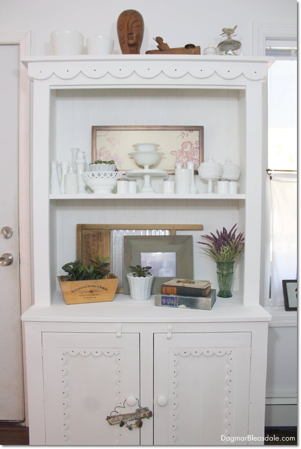 white hutch decorated with milk glass collection and other farmhouse decor items
