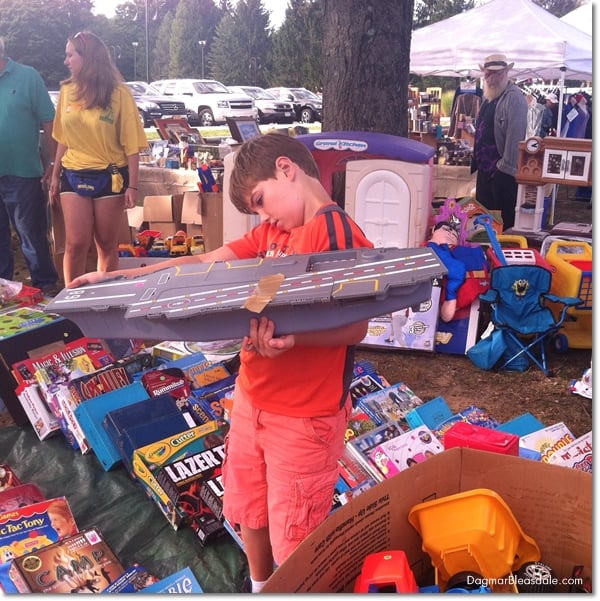 boy at rummage sale holding toy