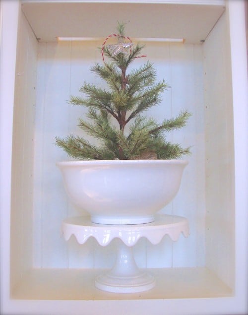 little tree in white bowl on pie stand 