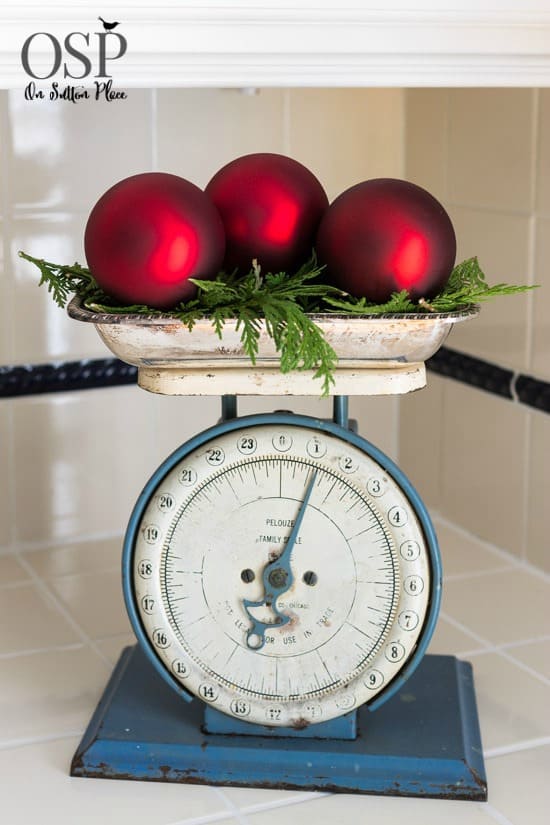 vintage scale with red Christmas ornament and greenery on kitchen counter
