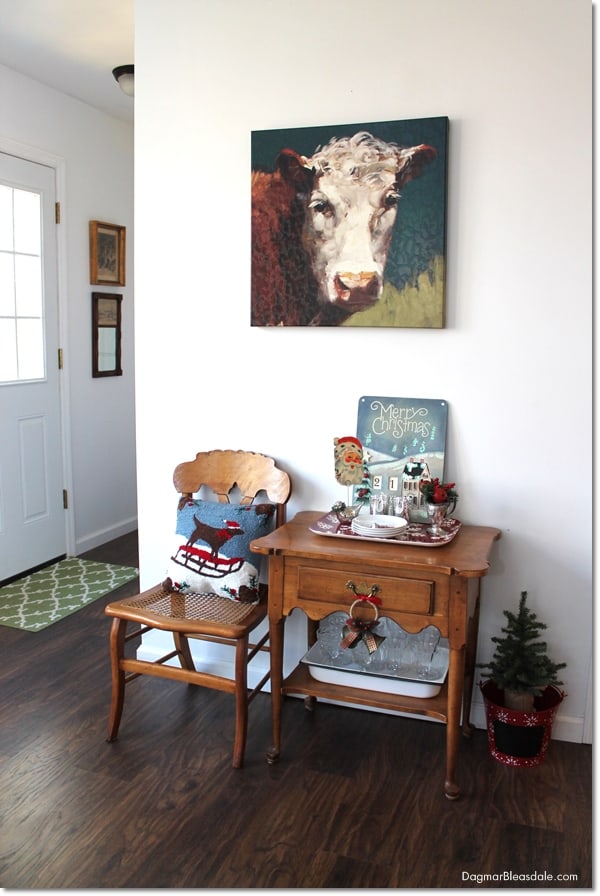 chair and table with Christmas decor, cow painting on wall