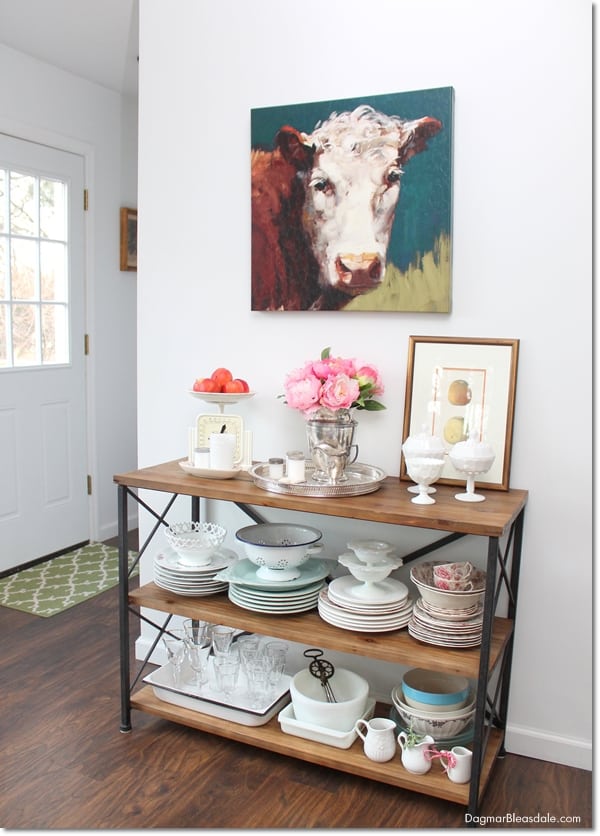 farmhouse console table with dishes and cow painting