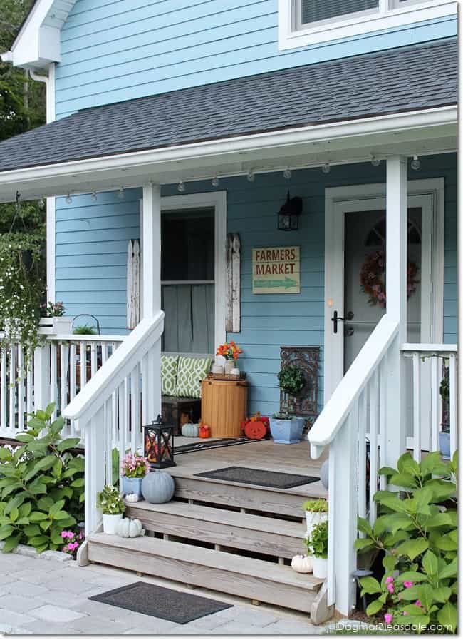 Blue Cottage porch with fall decor, lanterns with pumpkins