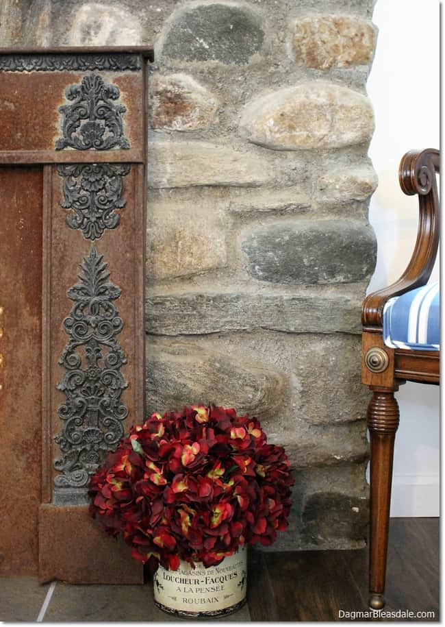 stone fireplace with metal frame and silk flowers
