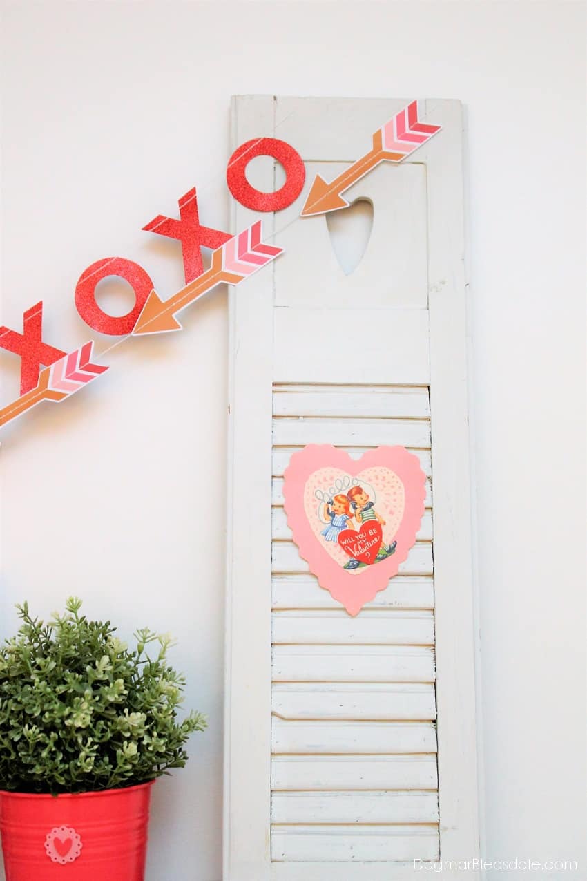 small shutter decorated on mantel with Valentine's Day banner and vintage Valentine