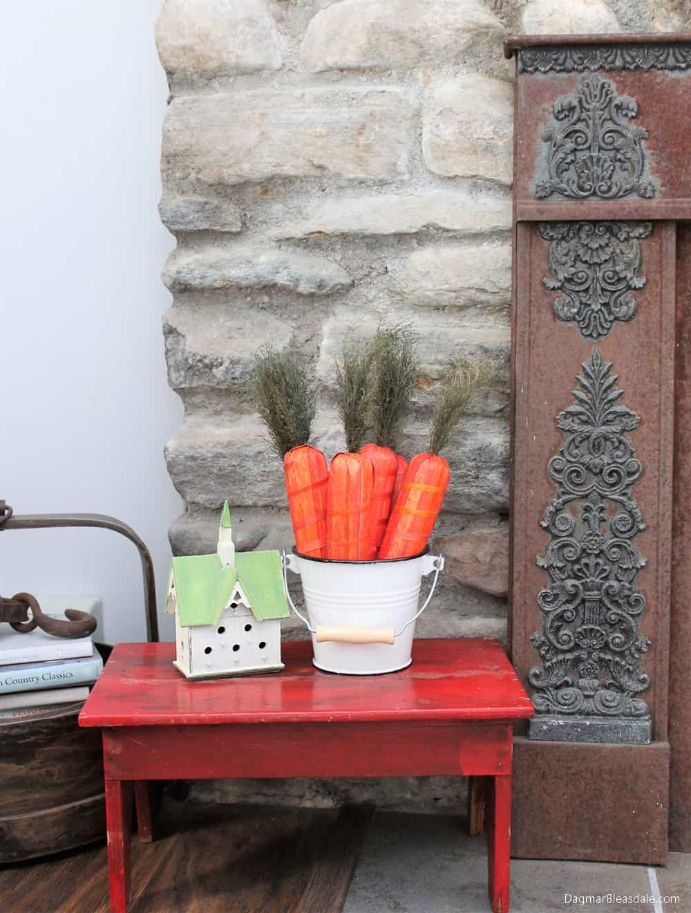little red table with basket filled with fake carrots and fireplace