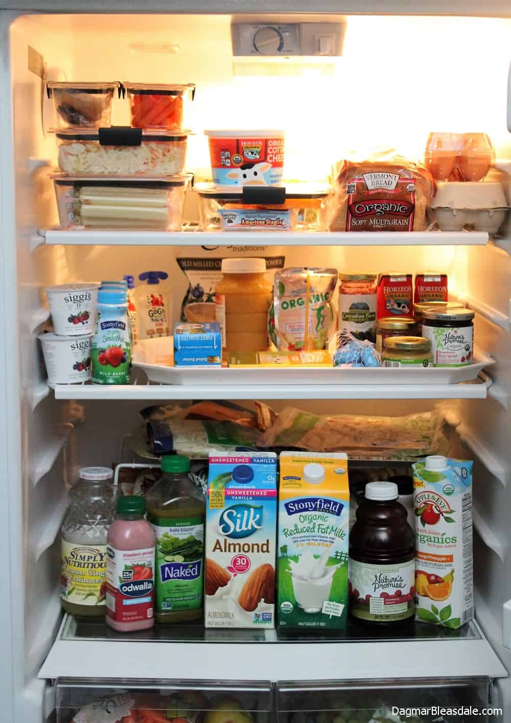 inside of refrigerator filled with organic food, some in clear containers
