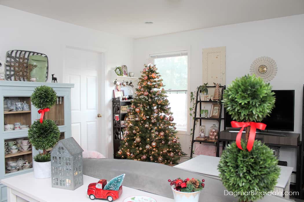 living room with Christmas tree with blush ornaments and other decor