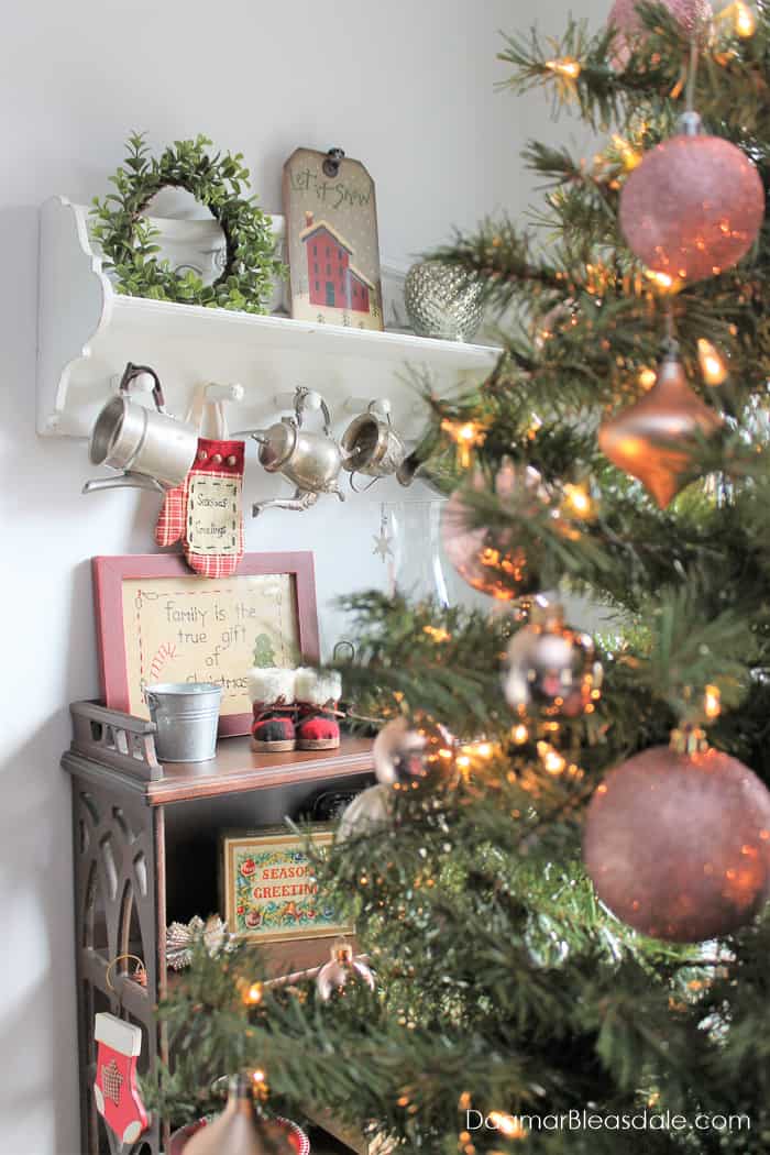 Christmas tree with blush ornaments and wall shelf full of Christmas decor