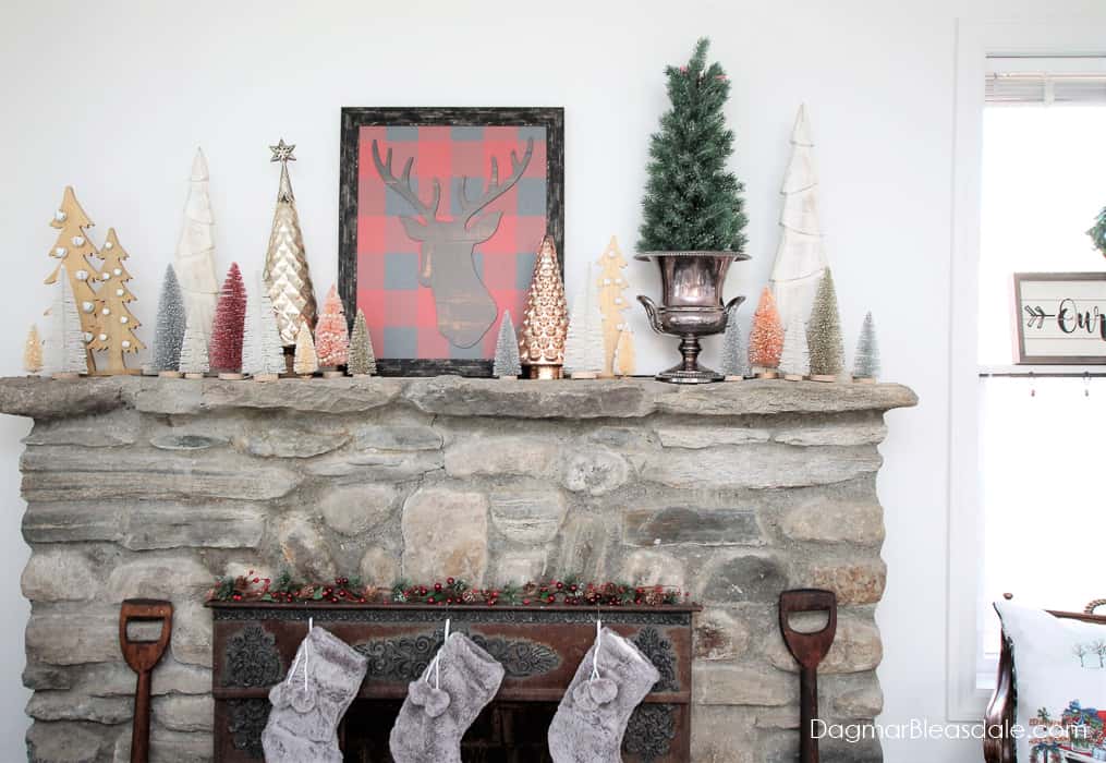 stone fireplace with Christmas decor and stockings and christmas trees