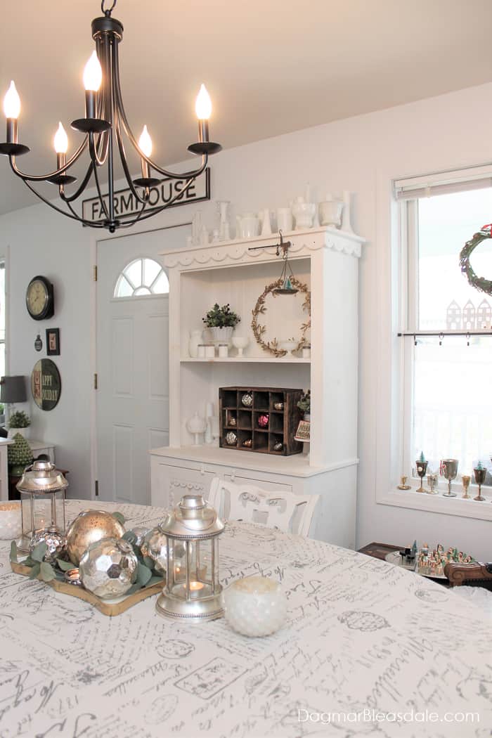 white living room with Christmas decor and chandelier, farmhouse sign