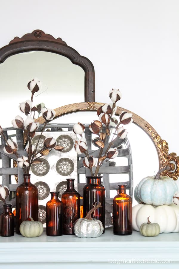fall decor with pumpkin and cotton stems and mirrors