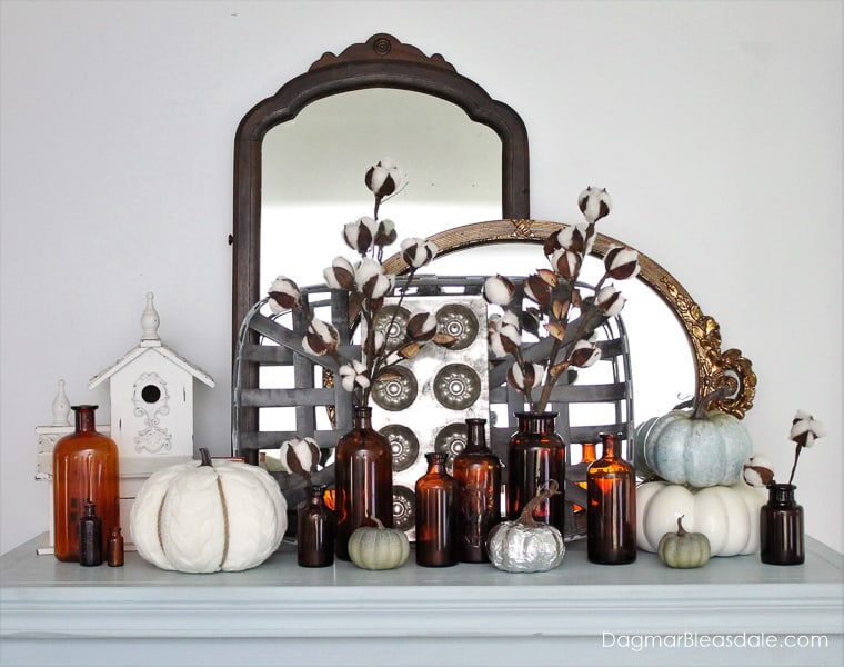amber bottles, pumpkins, and mirrors on dresser