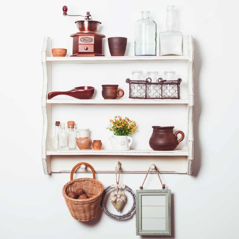 shabby chic kitchen shelf filled with bottles, jars, and coffee grinder