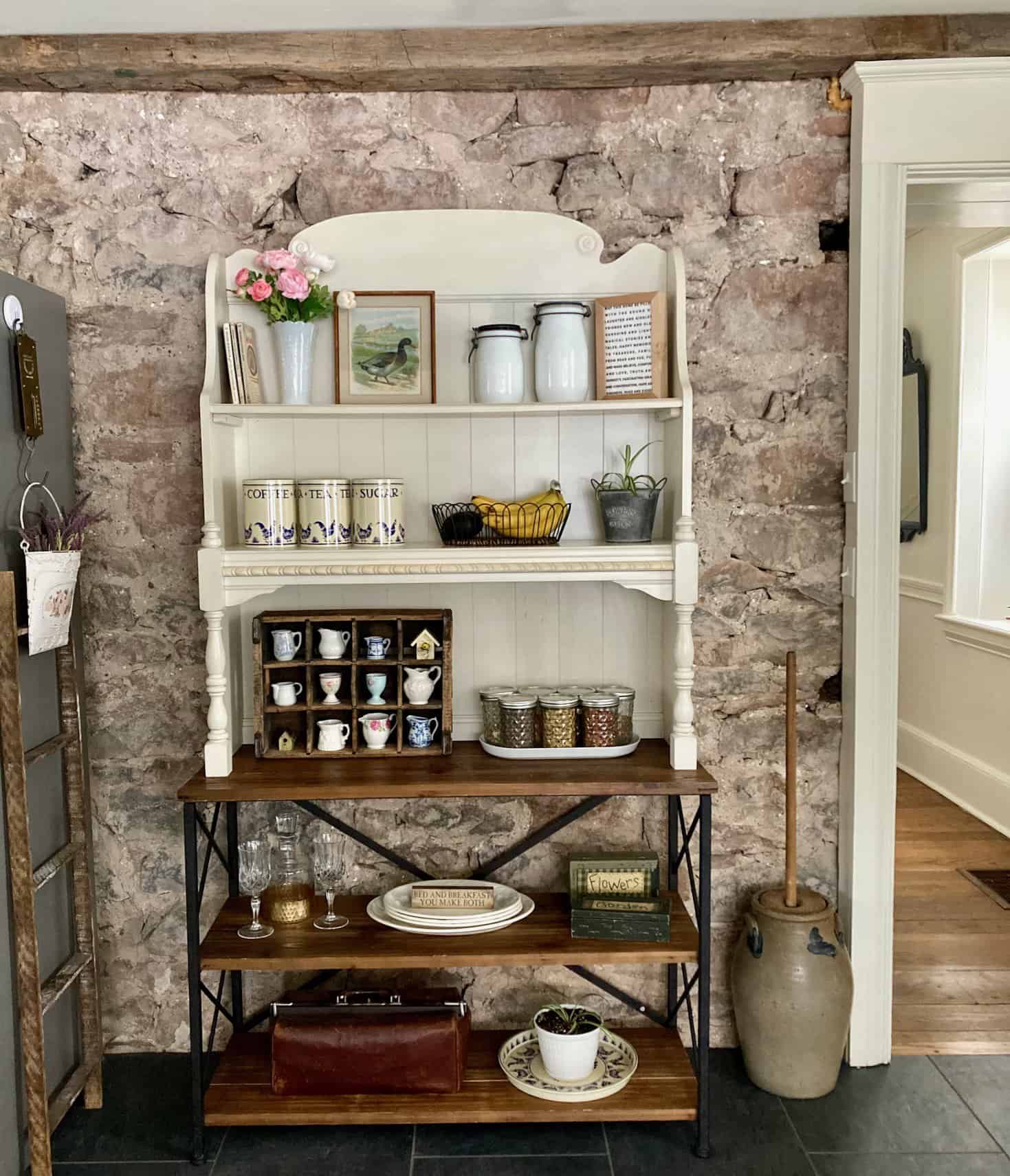 DIY hutch in farmhouse kitchen hutch in front of stone wall in the kitchen filled with decor